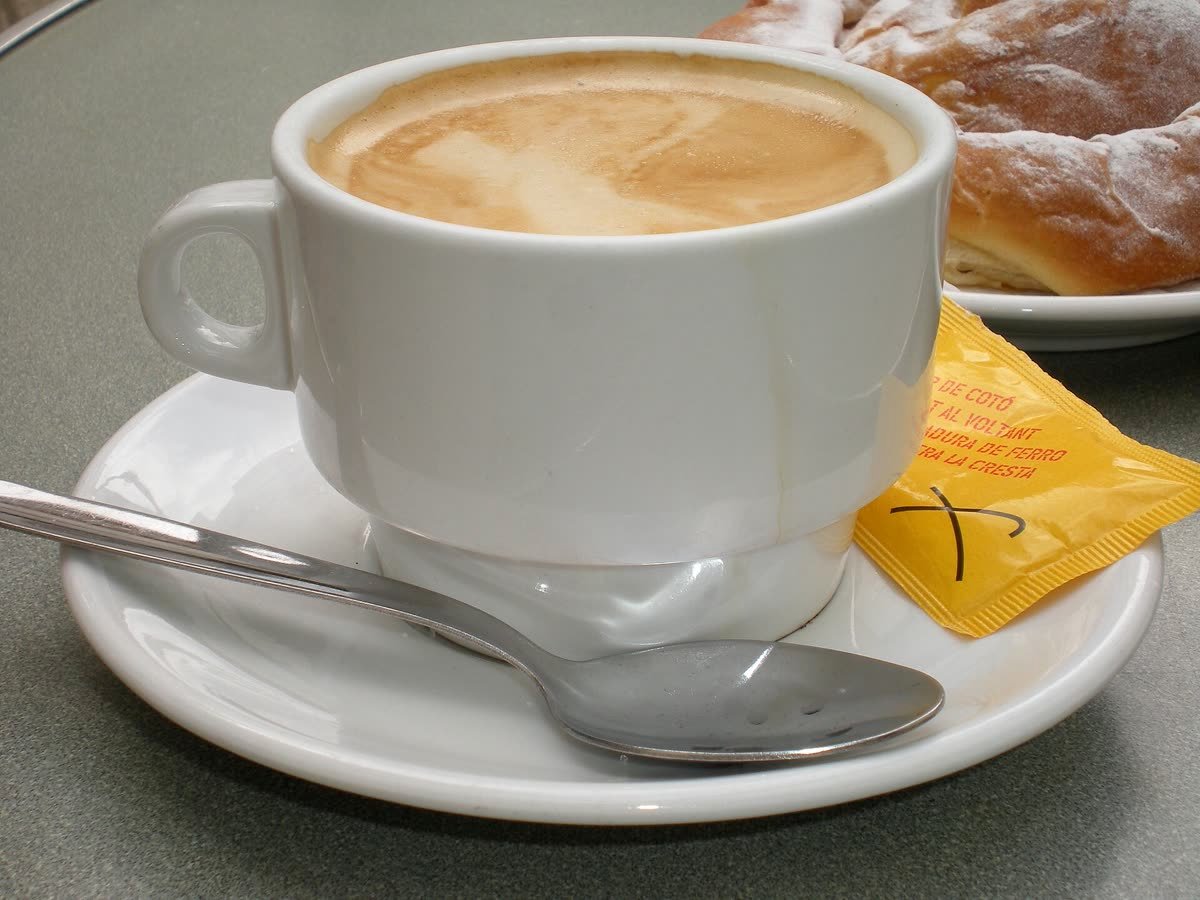 Taza de café con leche sobre la mesa de una cafetería