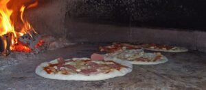 Pizza dentro de un horno de leña