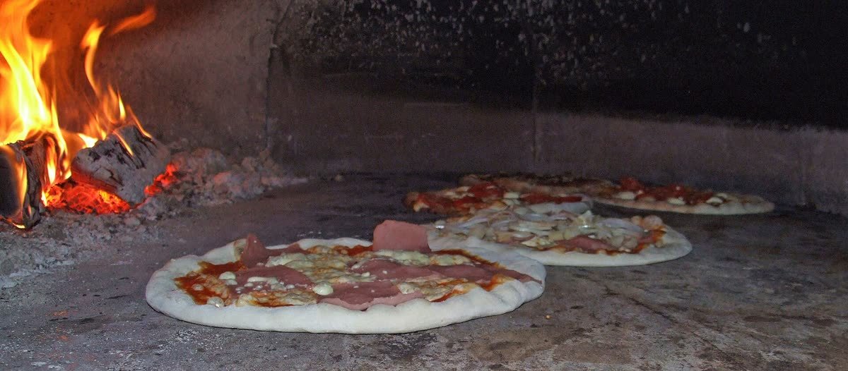 Pizza dentro de un horno de leña